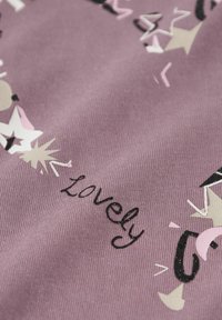 Baumwollstoff in einem gedämpften lila Farbton mit einem abstrakten Muster aus Sternen und dem Wort "lovely" in schwarzer Stickerei.