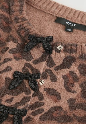 Brun leopardprickig trikåtyg med svarta paljettsnören, metallknappar och en NEXT-märkesetikett i kragen.
