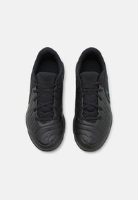 Zwarte sportieve schoenen met een gestructureerde synthetische bovenkant, voorzien van tonale veters, een gevoerde tong en een subtiele blauwe accent aan de zijkanten.