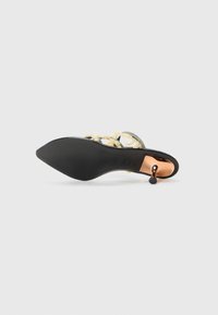 Svarte høye sandaler med spiss tå, prydet med gule dekorative elementer og en metallisk detalj på hælen. Glatt tekstur.