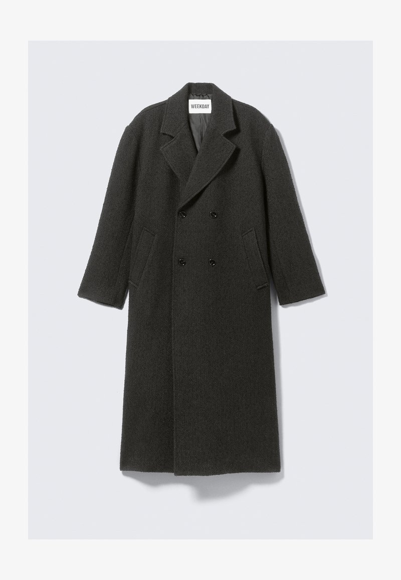 Σκούρο γκρι μάλλινο παλτό με διπλή σειρά κουμπιών, πέτο καπέλο και πλαϊνές τσέπες. Διαθέτει υφασμάτινη επιφάνεια και κόψιμο μέχρι το γόνατο.