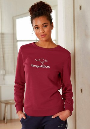Weinrotes Sweatshirt mit langen Ärmeln, rundem Halsausschnitt und "KangaROOS"-Logo. Weicher Stoff mit gerippten Bündchen und Saum. Lässiger Schnitt und glatte Textur.