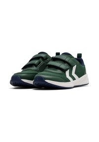 Grüne Sportschuhe mit weißen Streifen und Klettverschlüssen, die eine strukturierte Oberfläche und einen marineblauen Kragen aufweisen, nebeneinander positioniert.