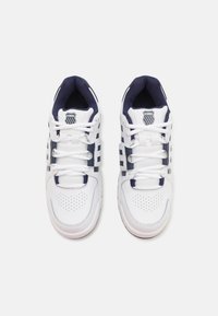 Baskets blanches avec des accents navy, présentant un revêtement en mesh, un bout perforé et un design classique à lacets. Logo K-Swiss sur la languette.