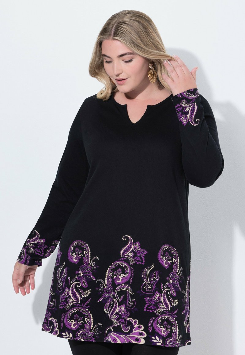Tunique noire avec décolleté en V et manches longues, ornée de motifs floraux complexes en violet et blanc le long de l'ourlet et des poignets.