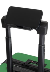 Groene koffer met zwarte hardware, voorzien van een uitschuifbare handgreep en een telefoonhouder bovenop. Glad oppervlak en zichtbare ritssluiting.