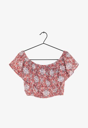 Top corto rojo de hombros descubiertos con mangas con volantes, con un patrón floral y geométrico en azul y blanco sobre una tela ligera.