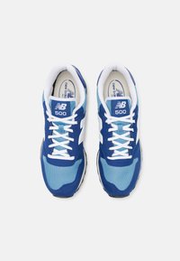 Modré a světle modré tenisky z materiálů síťoviny a semiše, bílé tkaničky, s logem "NB" a černou gumovou podrážkou.