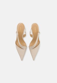 Beige pointed-toe slingback pumps with a smooth leather finish, featuring a single strap and subtle ankle buckle for secure fit.
