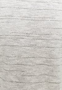 Tejido de punto gris claro con un patrón texturizado; presenta rayas horizontales y un tejido ligeramente suelto para una apariencia transpirable.