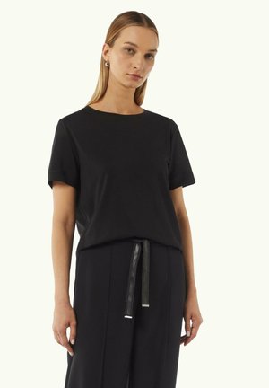 Zwarte T-shirt met korte mouwen van zachte stof en een ronde hals, gecombineerd met zwarte broek met een strikdetail bij de taille.