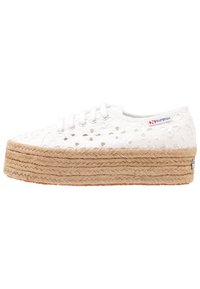 Hvide snørresneakers med blomsterudskæringer, en tyk jute platformssål og en struktureret, vævet overflade. Rød og blå logo på siden.
