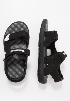 Sandales de sport pour enfants noires et grises avec brides Velcro réglables et semelles intérieures rembourrées texturées, vues de dessus et de côté.
