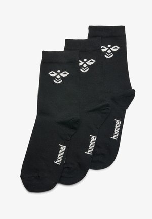 Czarne skarpetki bawełniane z białym logo pszczoły i napisem "hummel", o gładkiej fakturze i długości do kostki. Zestaw trzech par.