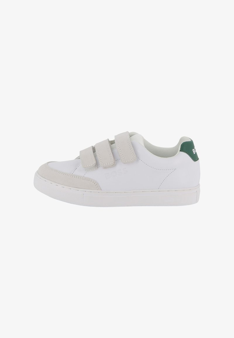 Baskets blanches avec des accents en daim gris, dotées de trois bandes velcro, d'une semelle texturée et d'un détail de logo vert sur le talon.