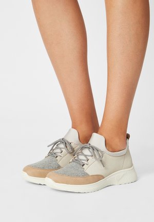 Beige and gray sneakers with a textured fabric upper, padded collar, and light laces, featuring a cushioned sole for comfort.