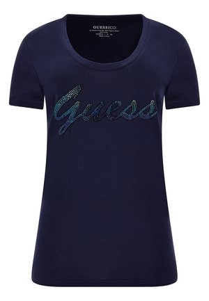 Granatowy damski t-shirt z krótkim rękawem, dekoltem w kształcie litery U i logo "Guess" wykonanym z małych niebieskich i czarnych cyrkonii na wysokości klatki piersiowej.