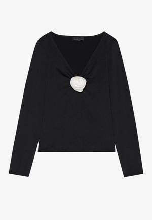 Haut à manches longues noir avec un décolleté en V profond et un accent en rose en tissu blanc au centre. Texture lisse avec une silhouette ajustée.