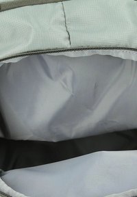 Interior de una bolsa de tela gris con un acabado suave y mate. Cuenta con un cierre de cremallera y un forro suave y flexible. No se observan compartimentos adicionales.