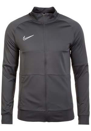 Czarna sportowa kurtka Nike z pełnym zamkiem, długimi rękawami i białym logo Nike swoosh na lewej piersi.