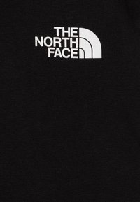 Fekete kapucnis felső, amelyen a "The North Face" fehér logója található ívelt formában. Az anyaga puha és texturált. Nincs további látható részlet.