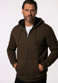 Brun zip-up hættejakke med blød inderside, justerbare snore, to frontlommer, ribbede manchetter og en lille logo-detale.