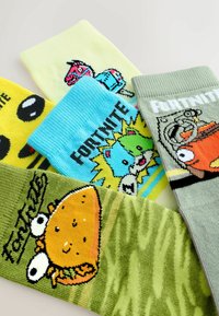 Mitmevärvilised multikate mustriga sokid; materjalid on ribastatud tekstuuriga. Kujundustes on toidutegelased ja mänguteemalised graafikad.