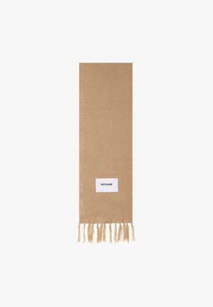 Beige scarf made of soft woven fabric. It features fringed ends and a small white label with black text. Long and rectangular shape.