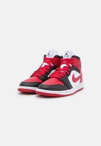 Zapatillas altas rojas y negras de cuero con detalles en blanco, que cuentan con puntera perforada, cordones gruesos y un logotipo icónico.