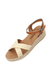 Sandalo zeppa con suola in juta intrecciata, fascetta incrociata in tessuto a righe gialle e bianche, cinturino marrone alla caviglia e soletta morbida color beige.