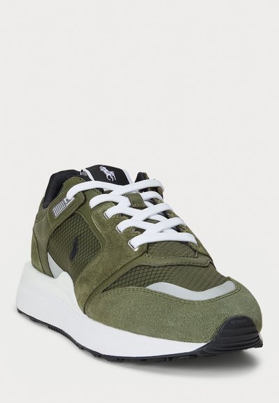 Groene suède en mesh sportieve schoen met witte veters, grijze accenten en een zwarte zool. Bevat merkgeving op de tong en de zijkant.