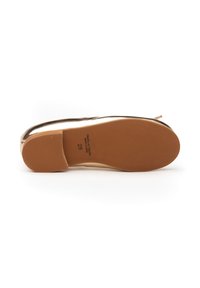 Zapato plano con un upper metálico brillante, punta redondeada y suela de goma duradera. Presenta un patrón texturizado para mayor agarre.