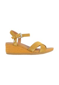 Sandali con zeppa in suede giallo, dotati di tacco a zeppa intrecciato, cinturino alla caviglia con fibbia e fasce incrociate sul davanti. Suola liscia per il massimo comfort.