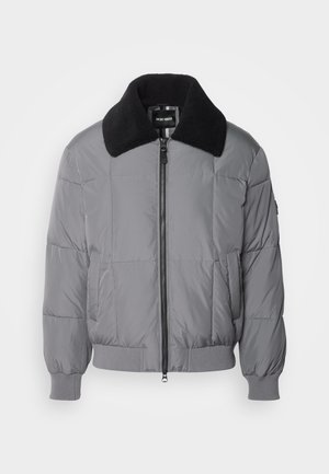 Jachetă puffer gri cu un guler texturat negru. Dispune de un fermoar în față, manșete ribbate și buzunare laterale. Design matlasat pe toată suprafața.