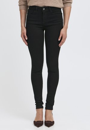 Jean skinny noir avec un design à cinq poches classique, une fermeture à bouton à l'avant et une jambe fuselée pour un look ajusté.