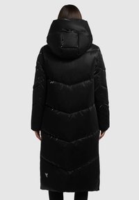 Zwarte gewatteerde lange jas met een grote capuchon, voorzien van een chevronpatroon, een glanzende afwerking en een logo detail nabij de zoom.