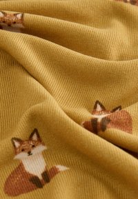Mustard fabric featuring a fox print, with a ribbed texture. The design displays multiple foxes in shades of brown and white.