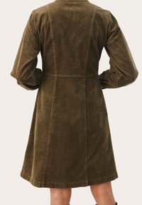 Robe en velours côtelé vert olive avec un corsage ajusté, une jupe évasée et des manches longues. Présente un côtelé vertical et un col simple.