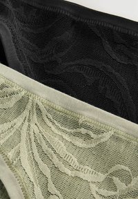 Tre paia di mutandine in pizzo da donna: una nera con un motivo testurizzato, una verde chiaro con un design floreale e fasce elastiche in vita.