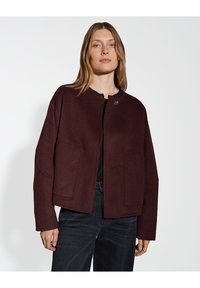 Burgundy wool jacket with a round neckline, two front pockets, and a single button closure. Features a relaxed fit with textured fabric.