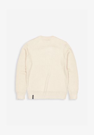 Beige gebreide trui met een ronde hals, geribbelde boorden en zoom, met een subtiele textuur en een klein merklabel aan de onderkant links.