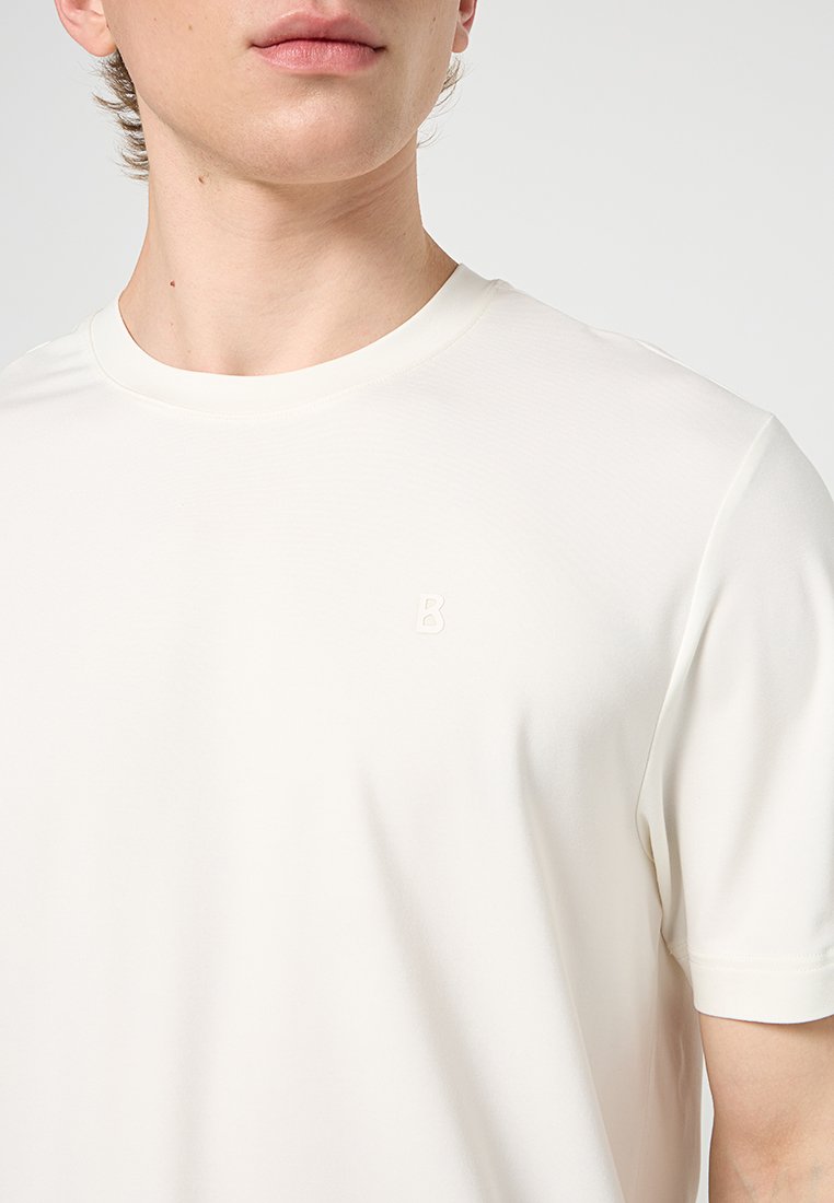 Hellbeige T-Shirt aus weichem, glattem Stoff. Mit Rundhalsausschnitt und dezent geprägtem Buchstaben "B" auf der Brust. Kurze Ärmel.