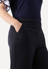 Marinblå randiga byxor med slim fit, som har vita nålrandiga detaljer, sidfickor och en mjuk tyger.