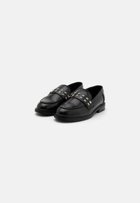 Svarte skinnloafers med rund tå, med sølvnagl på vampsiden, og såle i gummi som er lav og flat for komfort.