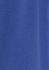 Tkanina z pevného, tmavě modrého látky s měkkým, strukturovaným povrchem, s rovnoměrným povrchem bez vzorů nebo ozdob.