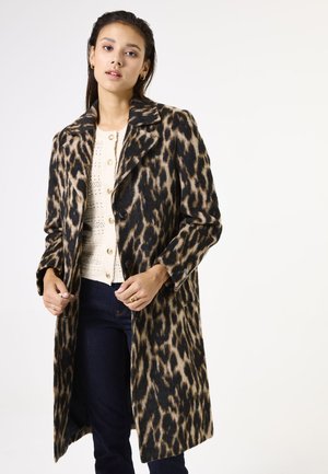 Manteau en laine à imprimé léopard avec col cranté, fermeture à boutons simple sur le devant et manches longues, associé à un haut léger et texturé.
