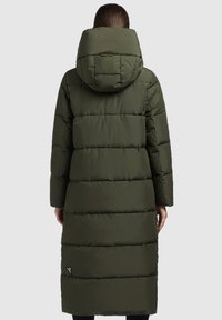 Lungo cappotto invernale imbottito di colore verde scuro, dotato di cappuccio, cuciture verticali e un'etichetta con logo in fondo. Tessuto liscio con un design trapuntato.