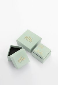 Trois boîtes à bijoux vert clair avec un marquage doré "elli premium", une ouverte montrant un intérieur noir, sur un fond blanc uni.