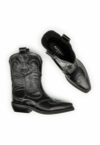 Mustad mustreeritud mustad nahkseelikud, valgete õmblustega, terava ninaga, dekoratiivsete mustritega ja krae küljes tõmblauad. Laminaalne talla.