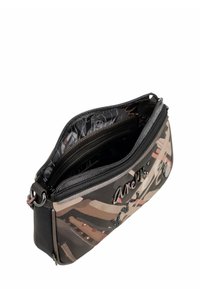 Pequeño estuche con cremallera con un patrón abstracto en tonos beige y marrón, compartimentos interiores visibles y un logo metálico decorativo en la parte frontal.